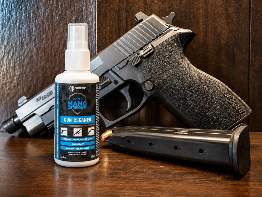 GNP Defend Gun Cleaner spray bottle beside a polymer-framed pistol on a wooden bench