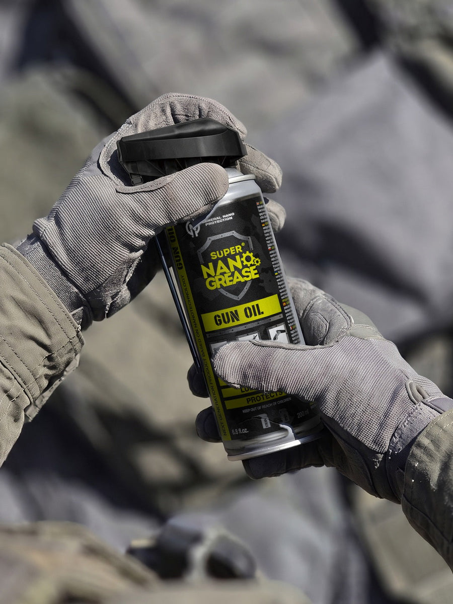 GNP Defend Gun Oil 200 ml can held in gloved hands