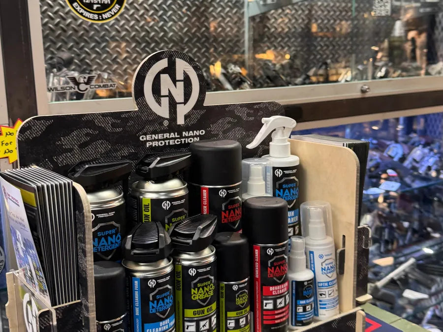 GNP Defend countertop display with literature rack on a dealer's counter in front of a pistol case